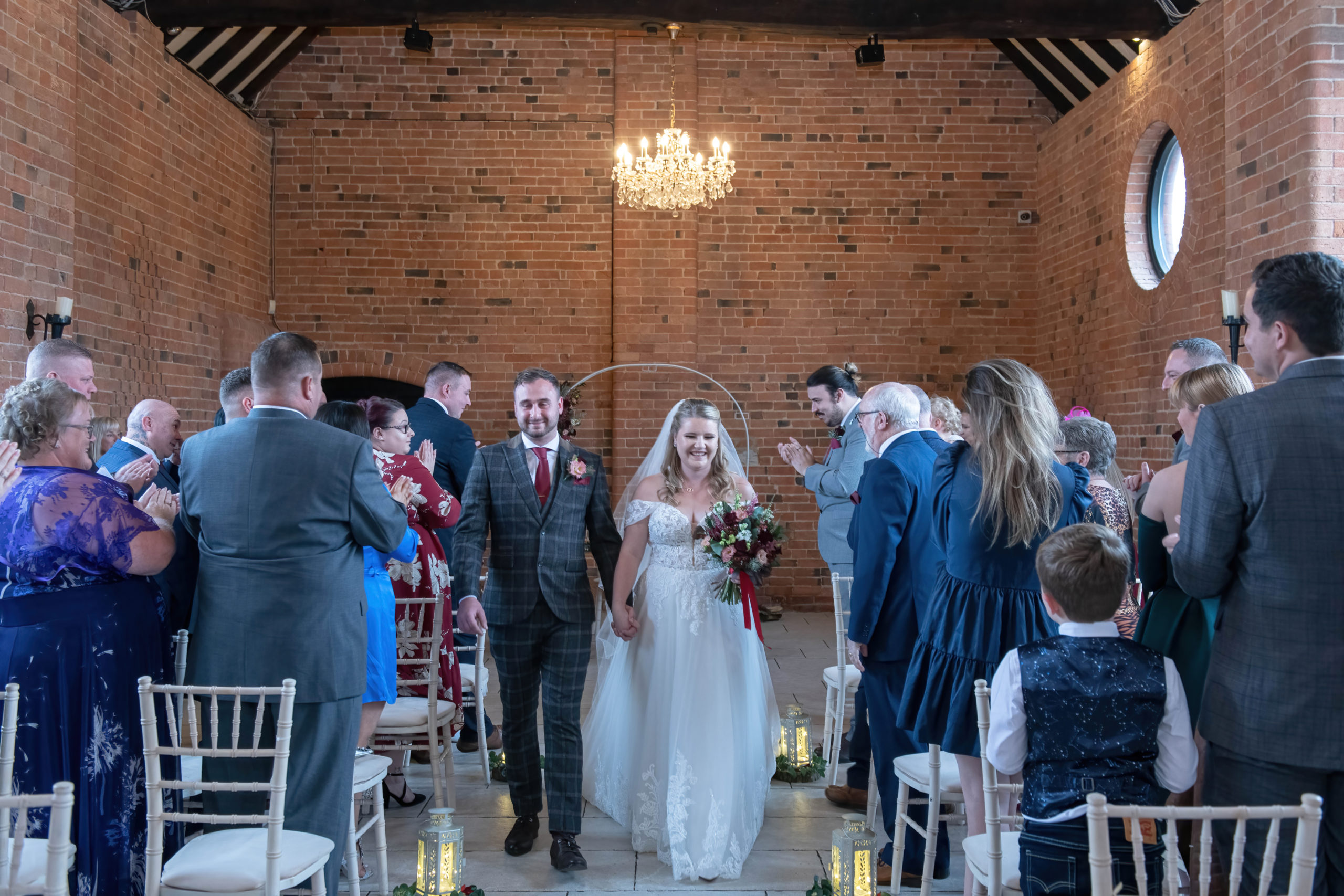 Bride and groom walking down the aisle at Meadow Barn