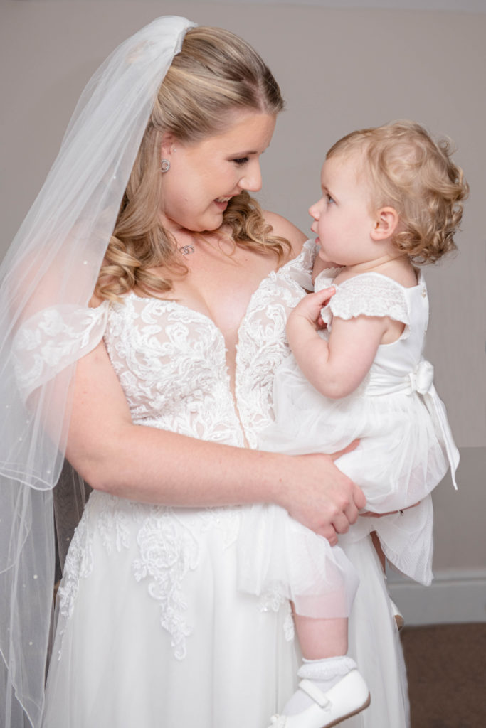 Bride holding hands with her daughter before the ceremony
