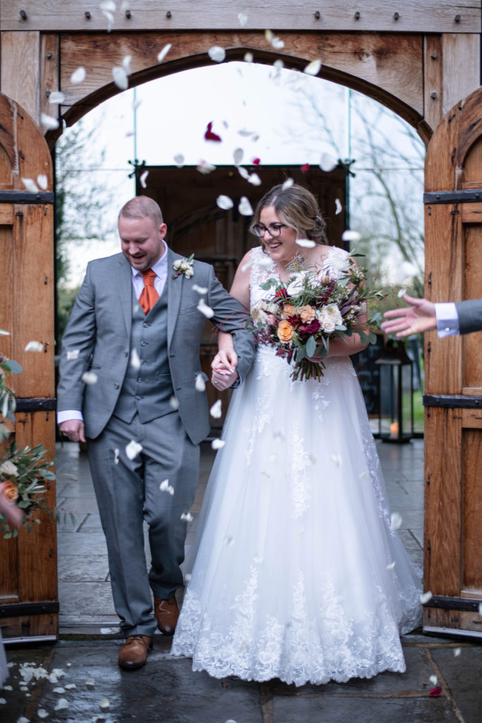 Confetti shot with cheering guests outside the barn