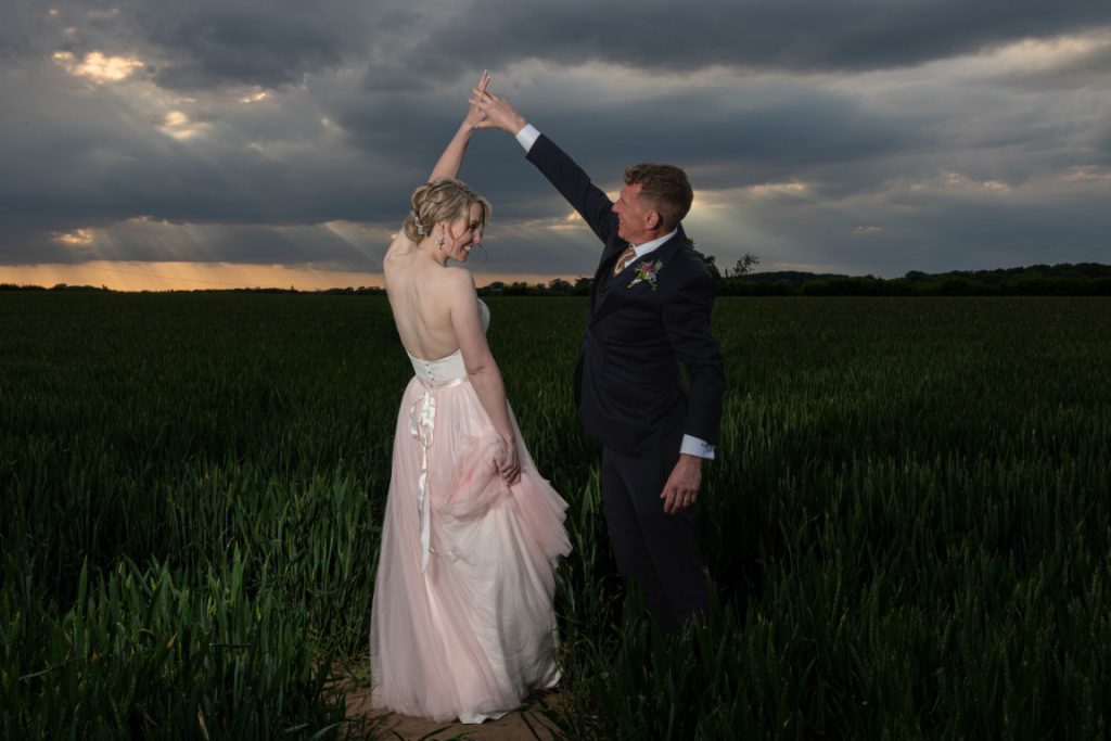 Michelle & Peter dancing at sunset in the field