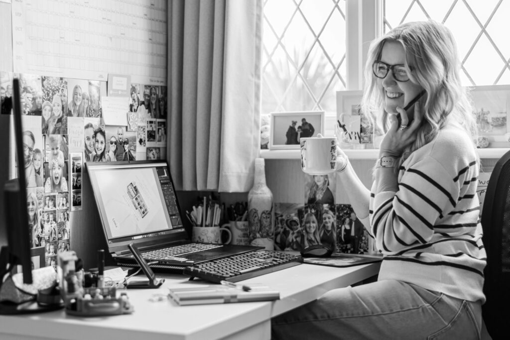 Leanne at her home office, chatting on the phone and drinking tea while editing photos – behind-the-scenes look at LB Photography